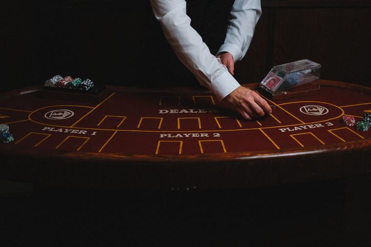 Dealer kasino membagikan kartu di meja permainan